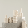 JARRONES MOLLY Conjunto de jarrones decorativos en tonos neutros sobre bloques de cemento.