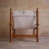 Vista trasera de la butaca de madera con cojines blancos de La Maison Barcelona, mostrando su diseño robusto y elegante
