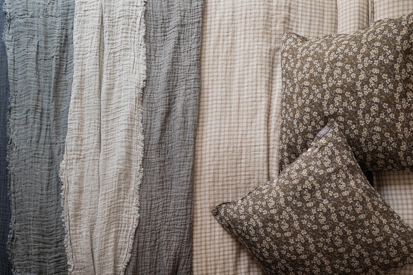 Detalle de manta a rayas azules y grises sobre cama.