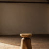 Taburete de madera con diseño único en una habitación con luz natural