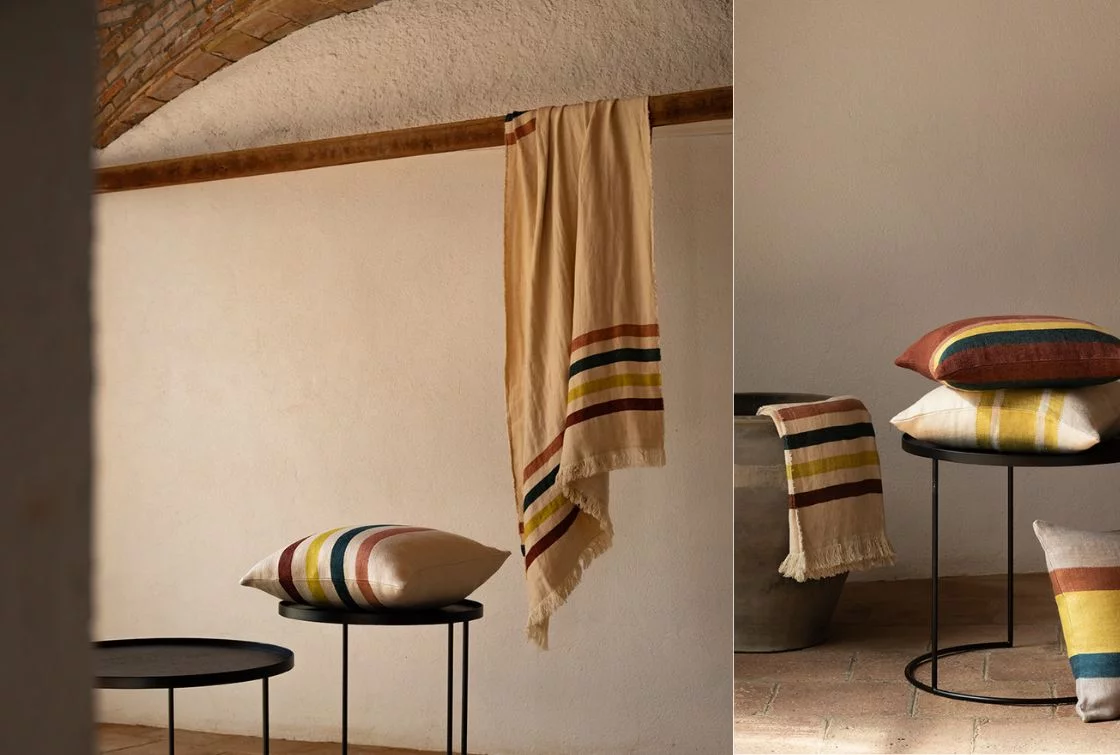 Dúo de imágenes con cojines a rayas de colores variados y manta a rayas colgada en ambiente interior rústico con mesas auxiliares negras